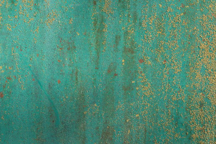 A metal surface stained green by copper oxidation