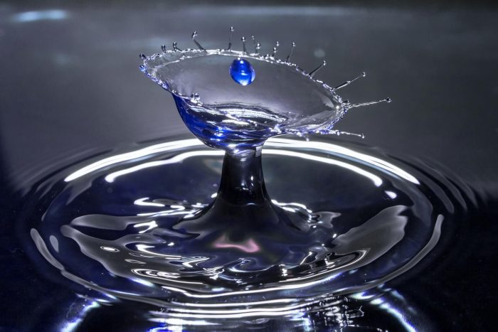 An image of a drop of water hitting a pool of water, captured in slow motion
