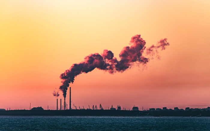 An image of a factory with a large smokestack polluting the air