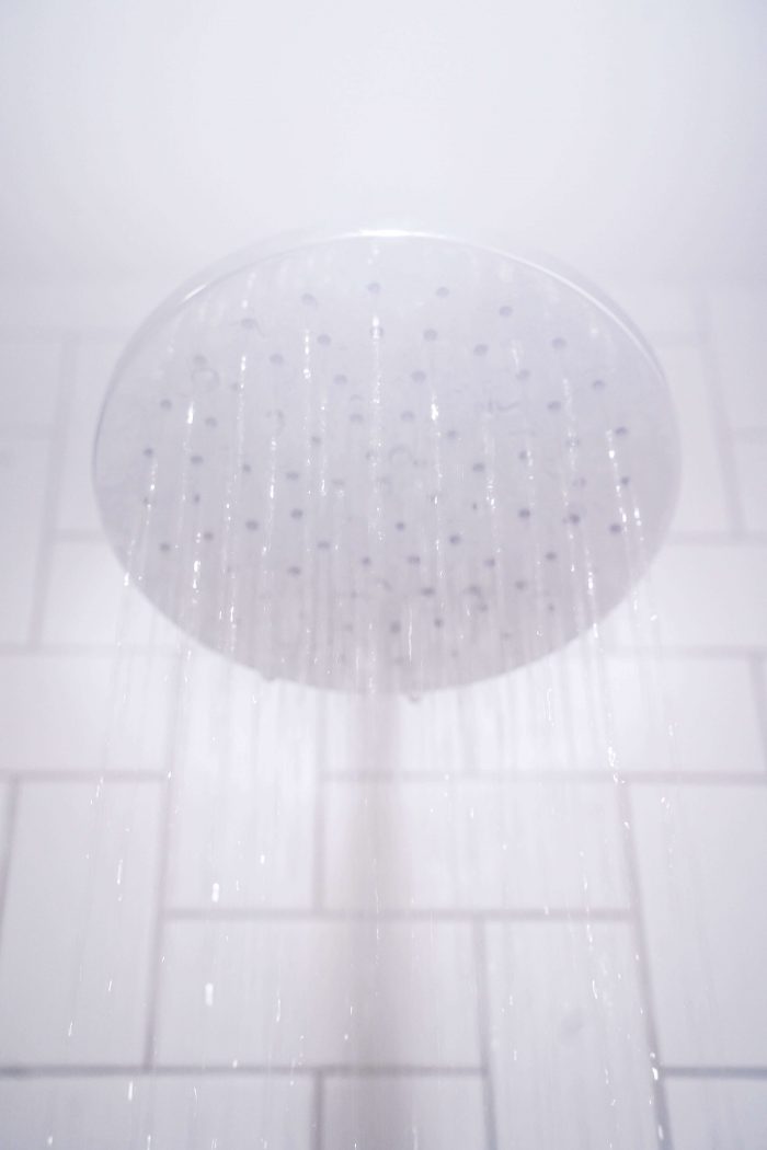 An image of a shower head with water and steam pouring out of it.